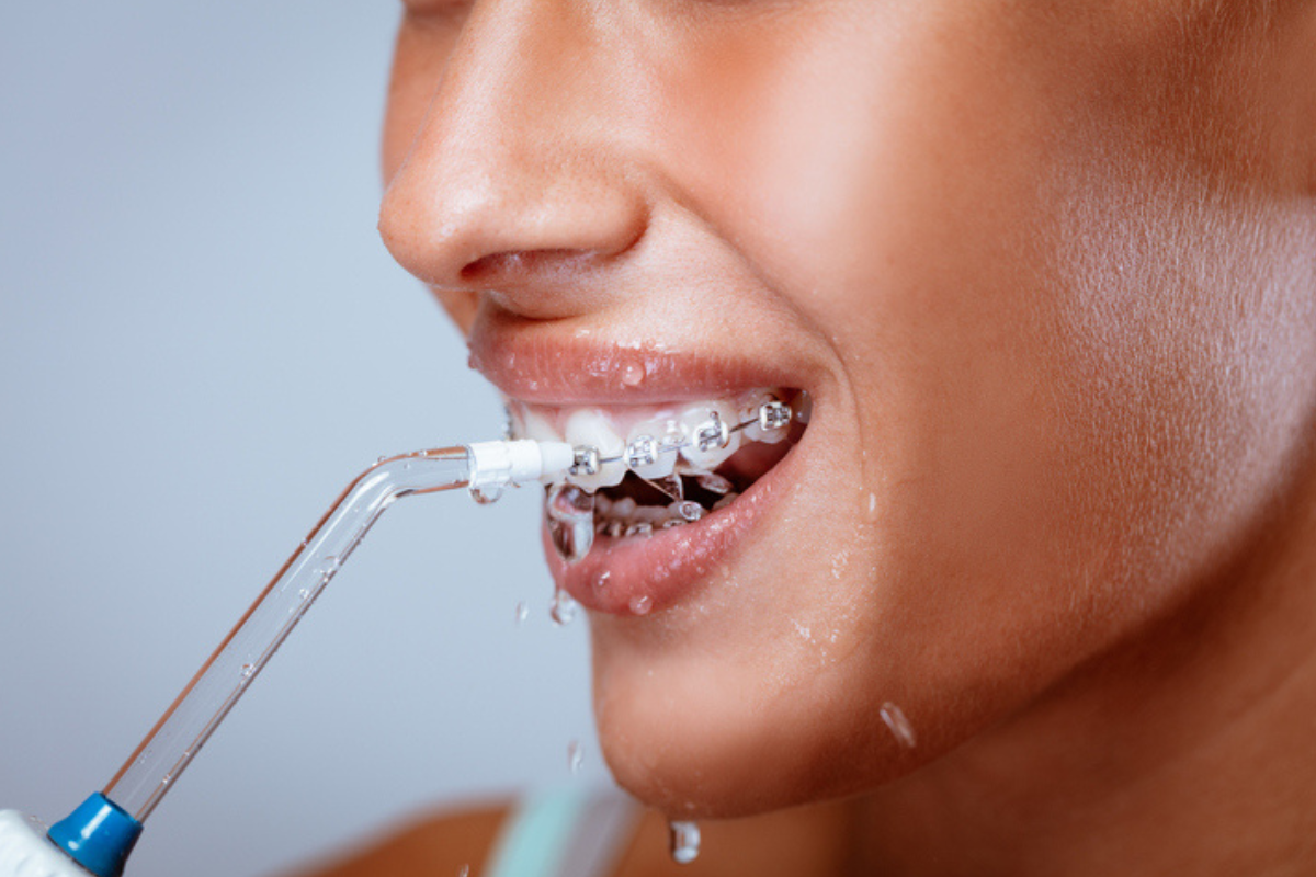 Person with braces using a water flosser.